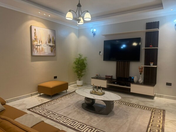 Apartment, 1 Bedroom | Living area | 65-inch Smart TV with digital channels, DVD player, pay movies - Masanyu Suites (Kampala)