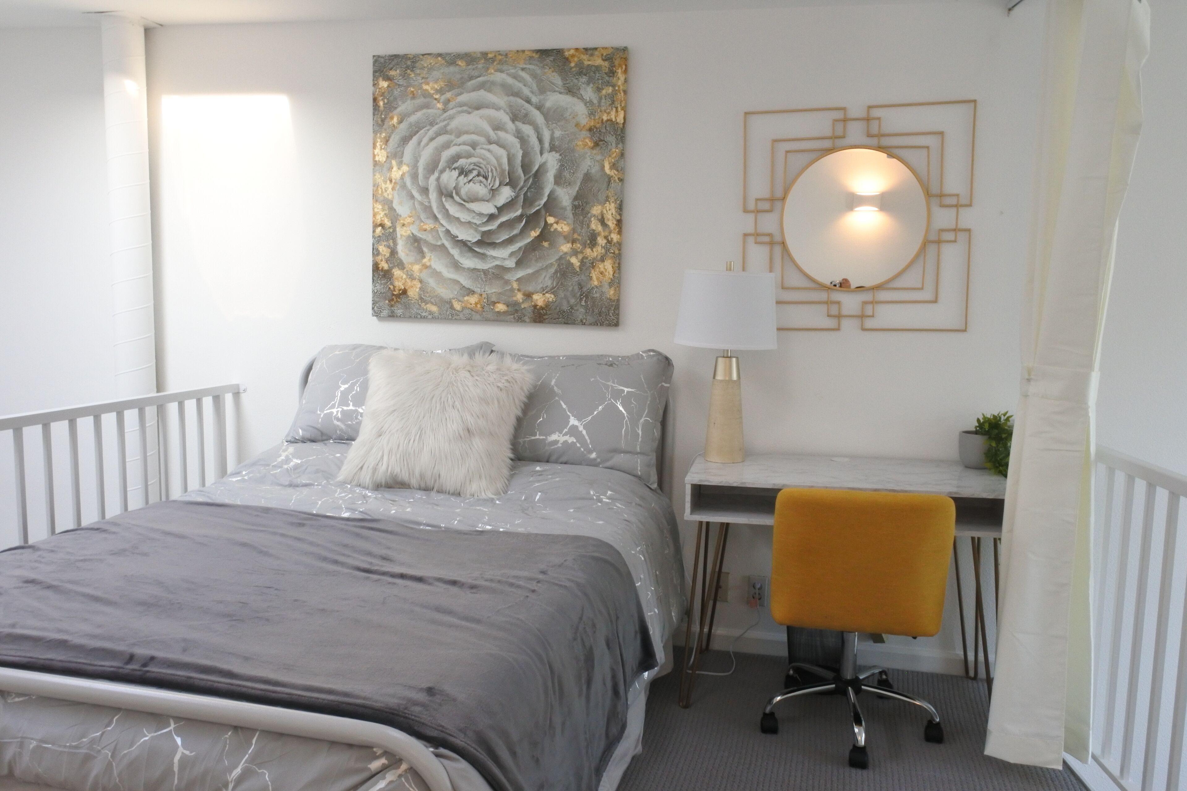 A modern bedroom with a bed, a desk, and a chair.