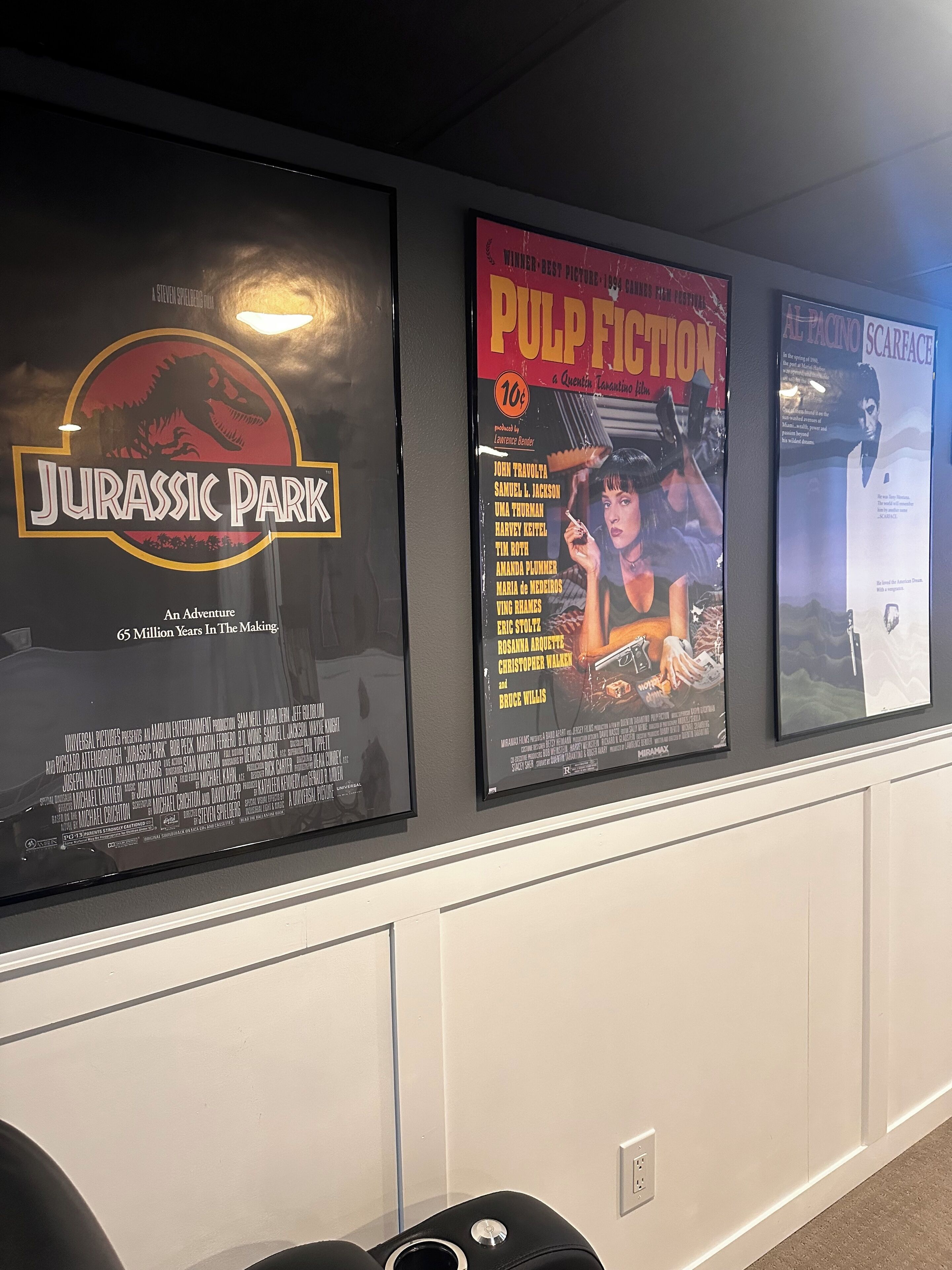 Framed movie posters on a wall, including 'Jurassic Park' and 'Pulp Fiction'.