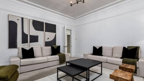 En moderne stue med to sofaer, et sofabord og et tæppe.