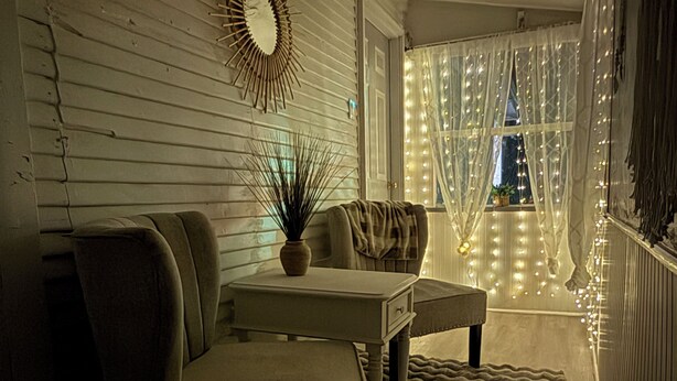 Un salon chaleureux avec un canapé, une petite table et un miroir décoratif.