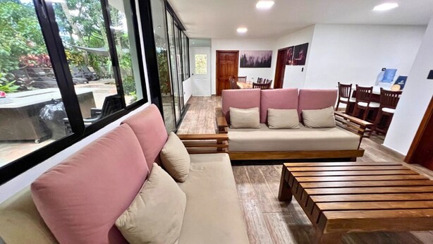 Una sala de estar moderna con un conjunto de sofá, una mesa de centro de madera y un comedor con sillas y una mesa.