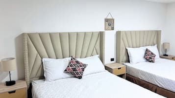 Two twin beds with headboards, white bedding, and patterned pillows.