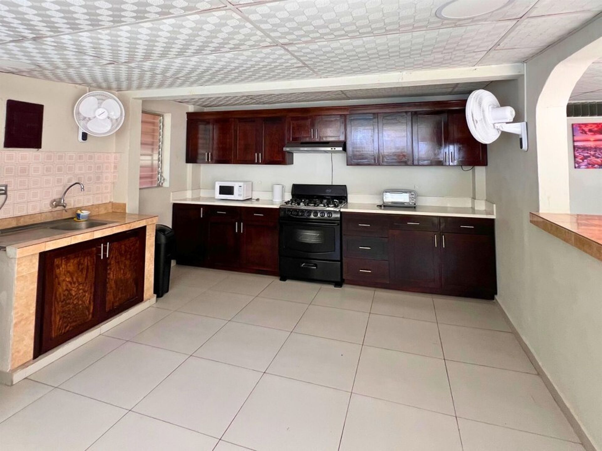 Una cocina compacta con estufa a gas, microondas y pileta.