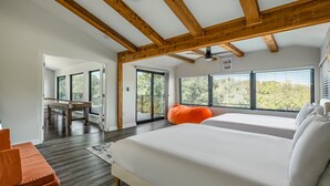 Une chambre avec un grand lit, un plafond en bois et une vue sur l’extérieur.