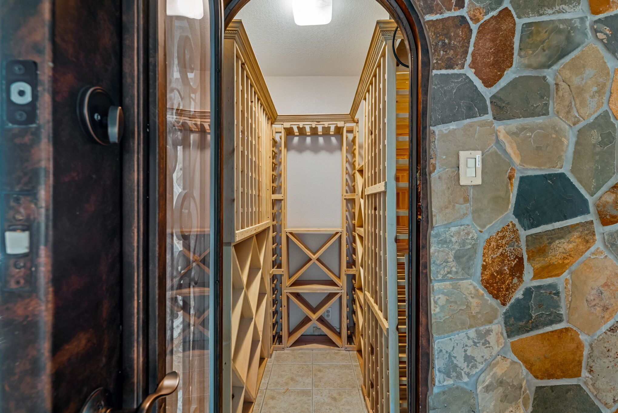 A narrow hallway with a stone wall on one side and a wooden door frame on the other.