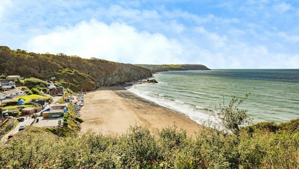 A coastal village with houses along the beach, a clear sky, and a view of the sea. - Laburnum, Tresaith - Two Bedroom Cottage, Sleeps 4 (Tresaith)