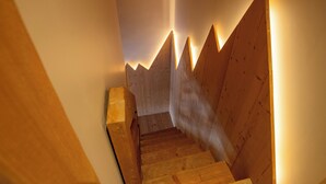 Una escalera de madera con un diseño geométrico original e iluminación cálida.