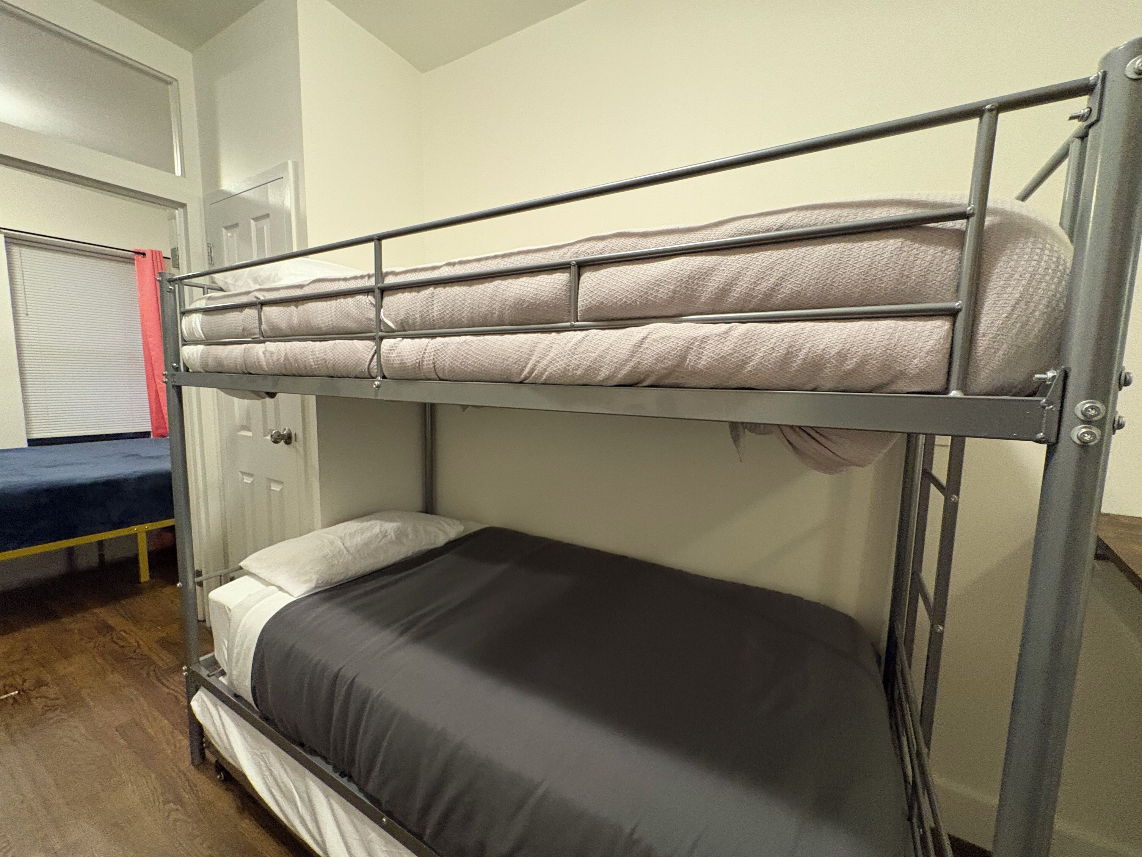 Un lit superposé avec un matelas et un lit inférieur avec un oreiller.