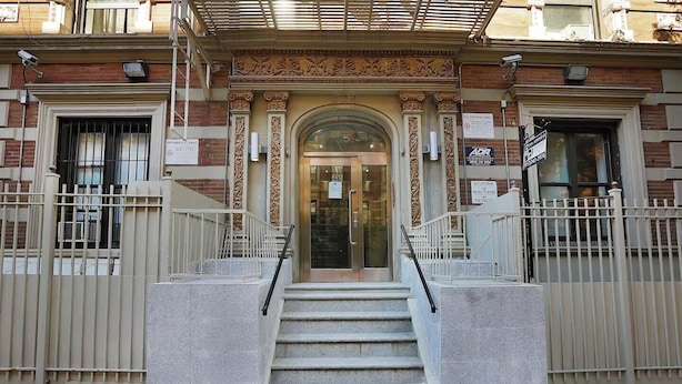 A building entrance with ornate architectural details, a set of stairs leading to the door, and multiple signs including a no trespassing sign. - Spacious 4BR/2BA duplex apt w/ private patio, W/D (New York)