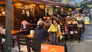Ein Restaurant namens Doner House mit Außenbestuhlung und einem Schild, das Özel Sosli bewirbt.