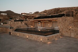 Ein Steinhäuschen mit Pool, Außenbereich und Blick auf die umliegende Landschaft.