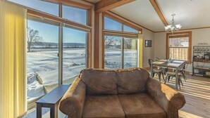 A cozy interior with a leather sofa, dining table, chairs, and a coffee bar.