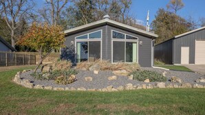 A modern house with a garage, a well-maintained garden with rocks and plants, and a clear sky.