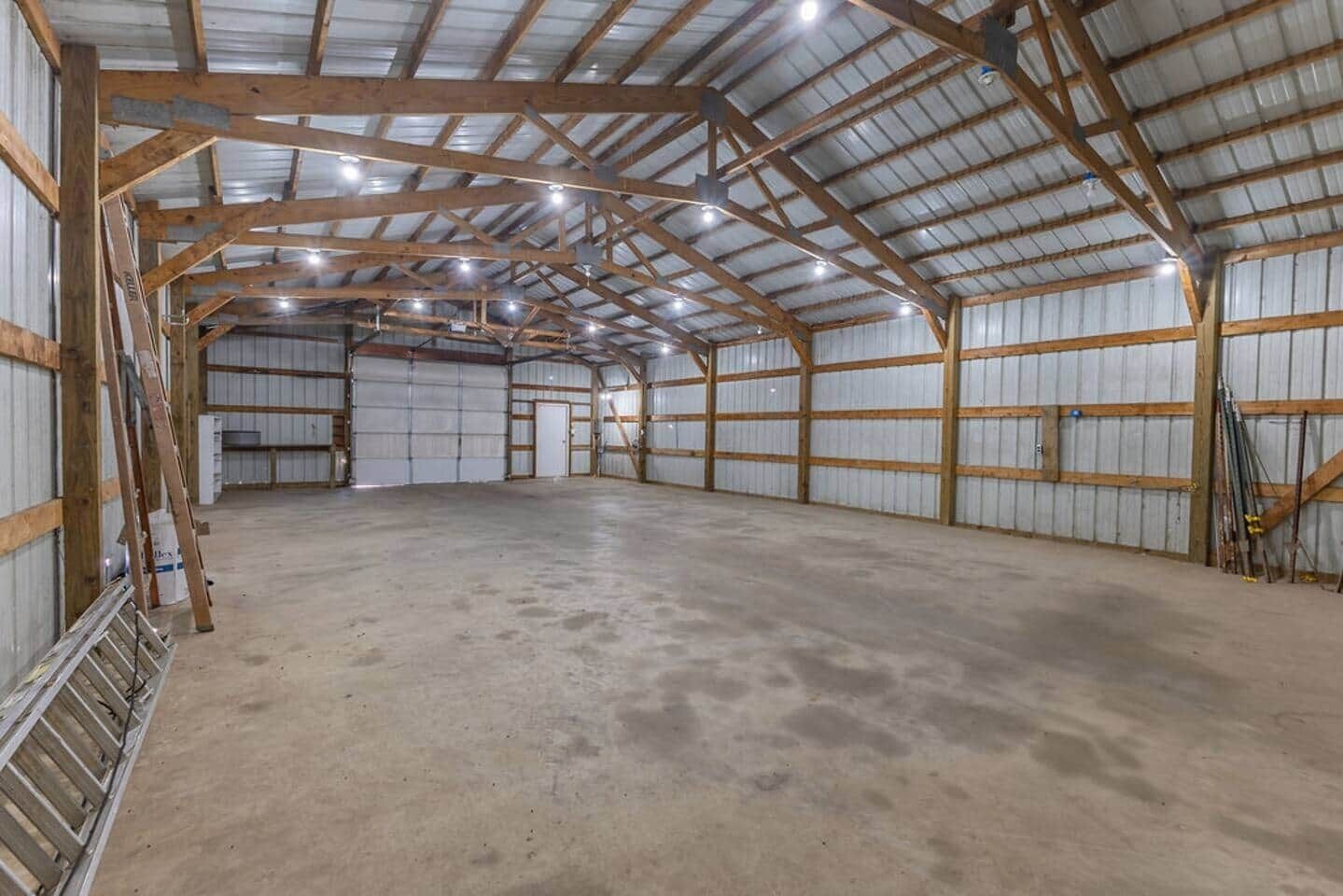 A large, empty warehouse with high ceilings and metal walls.