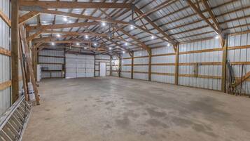 A large, empty warehouse with high ceilings and metal walls.