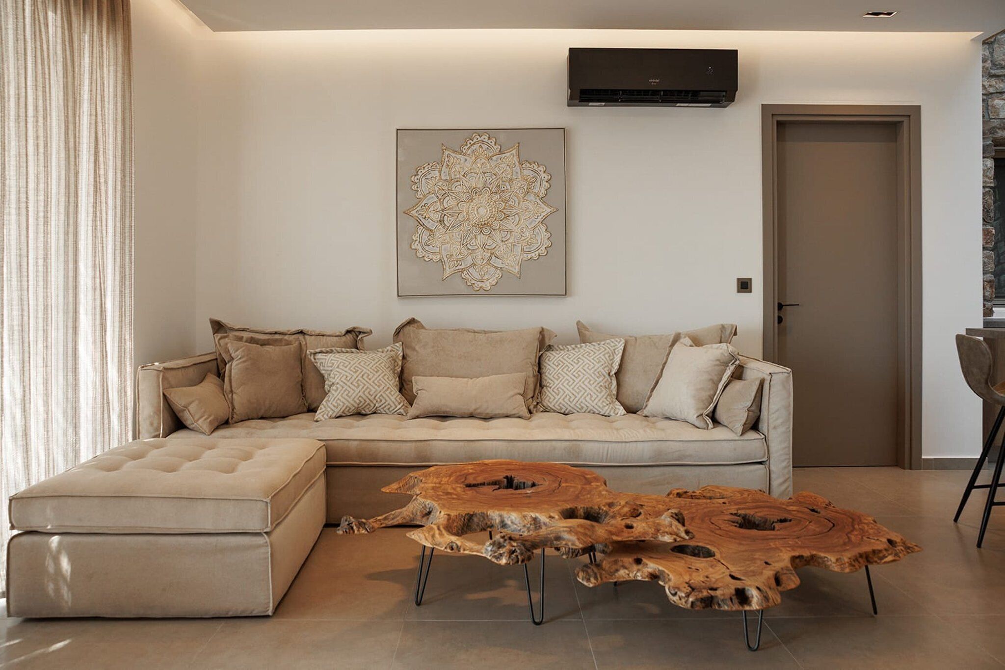 Una sala moderna con un sofá modular, una mesa de centro de madera y un adorno en la pared.