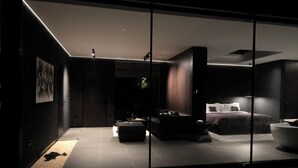 Une chambre à coucher moderne, dotée d’un lit, d’un coin salon et d’une grande fenêtre.