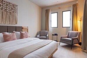 A hotel room with a large bed, two armchairs, a small table, and a wall-mounted decorative piece. - 304 Fabulous Apt near La Diana/Reforma/U.S Embassy (Mexico City)