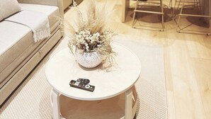 Una sala de estar moderna con un sofá, una mesa redonda de centro y una planta decorativa.
