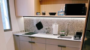 Et moderne køkken med en granitbordplade, rustfrie stålapparater og et rundt spisebord.