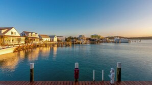 A waterfront property with docked boats, a wooden deck, and a marina. - 1 Bedroom Villa - Sunset Point, Abaco -SeaScape Villa # 9 (Elbow cay)
