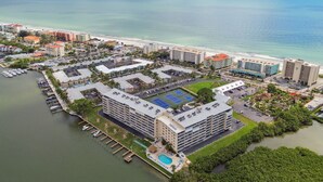 An aerial view of a coastal hotel complex with multiple buildings, a marina, and a beach. - Charming Waterview Condo | 6 min wlk to beach! (Indian Shores)