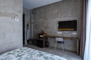 A small, compact room with a bed, a desk, a chair, a TV, and a shower. - Chrisenbel Hideaway Retreat, The Villa Collection by Chrisenbel (Petaling Jaya)