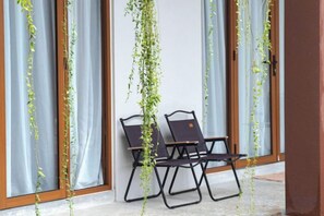 A room with a window, a chair, and a hanging plant. - Chrisenbel Hideaway Retreat, The Villa Collection by Chrisenbel (Petaling Jaya)