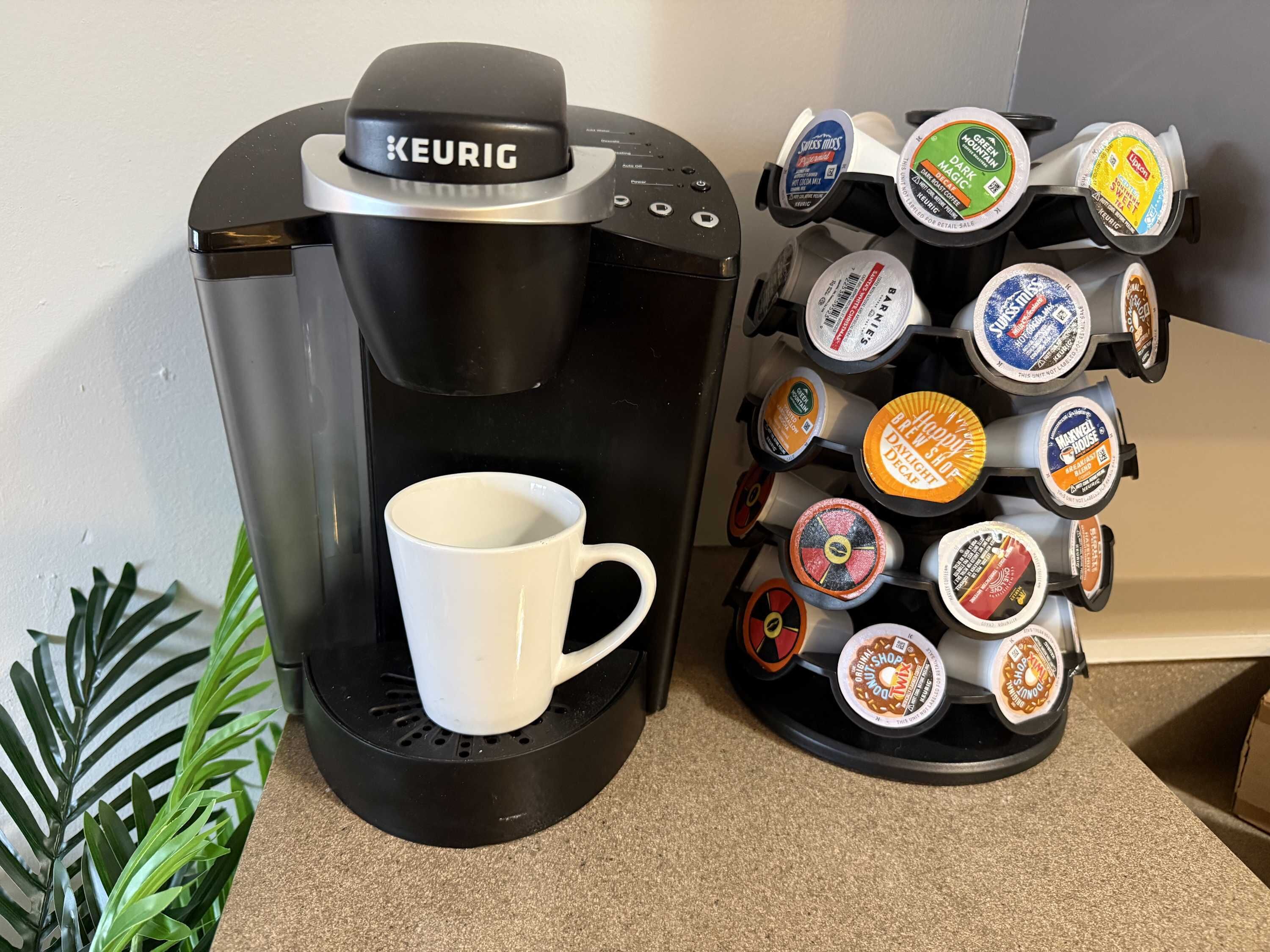 A Keurig coffee machine with a mug and a coffee pod holder.