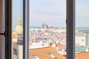 Blick durch ein Fenster auf eine Stadtansicht mit markanter historischer Architektur, darunter ein großes Kuppelgebäude und Türme.