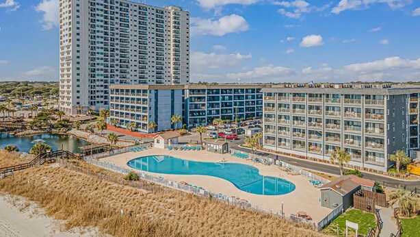 A hotel with multiple buildings, a central pool, and a beach area. - Rest & Relax - Beachfront Resort (Myrtle Beach)