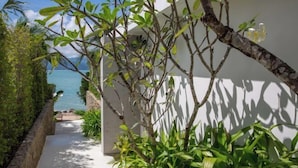 Un chemin menant à un bâtiment blanc d’où l’on peut admirer l’océan.
