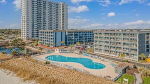 A hotel with multiple buildings, a central pool, and a beach area. - Sun & Fun - Rest & Relax (Myrtle Beach)