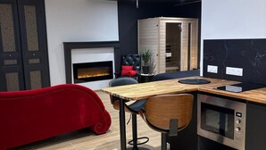 Een moderne keuken met een ingebouwde oven, een rode bank en een zwarte stoel.