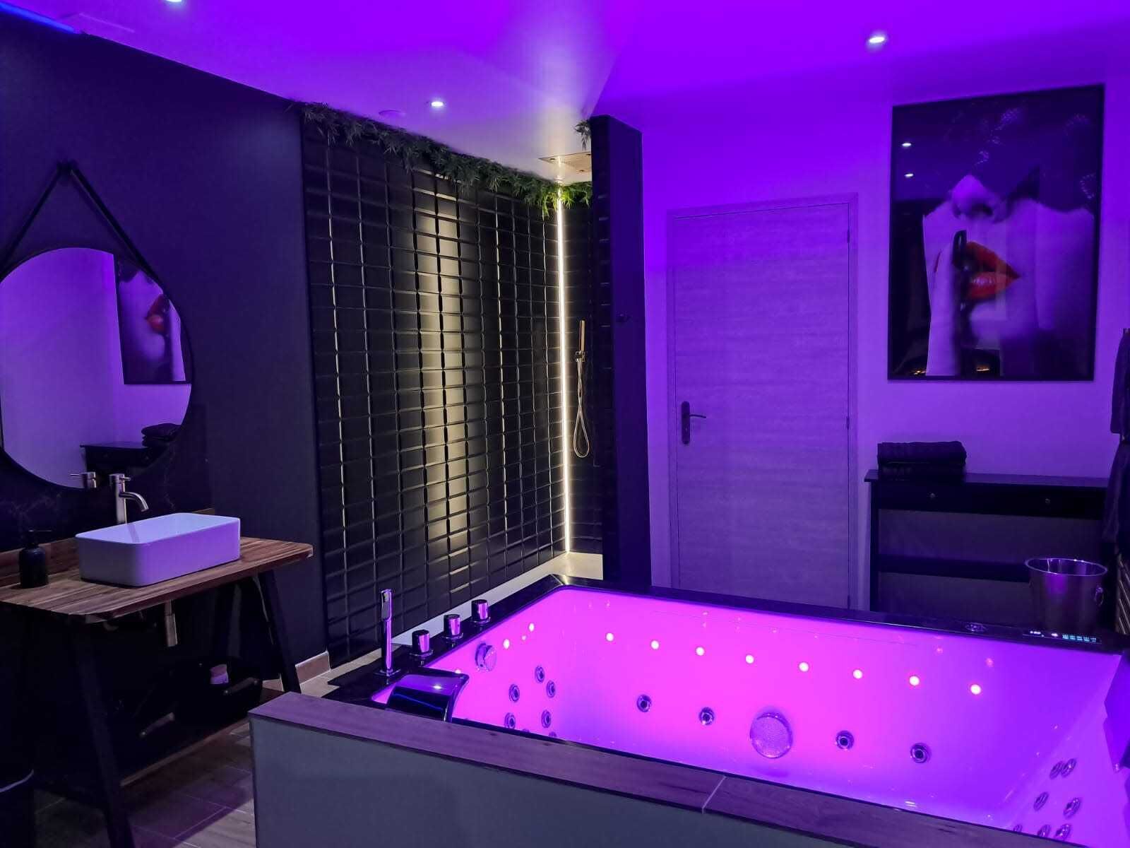 A modern bathroom with a large bathtub, a sink, and a shower area.