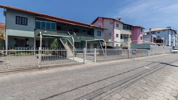 A residential street with houses, a gated entrance, and a paved road.