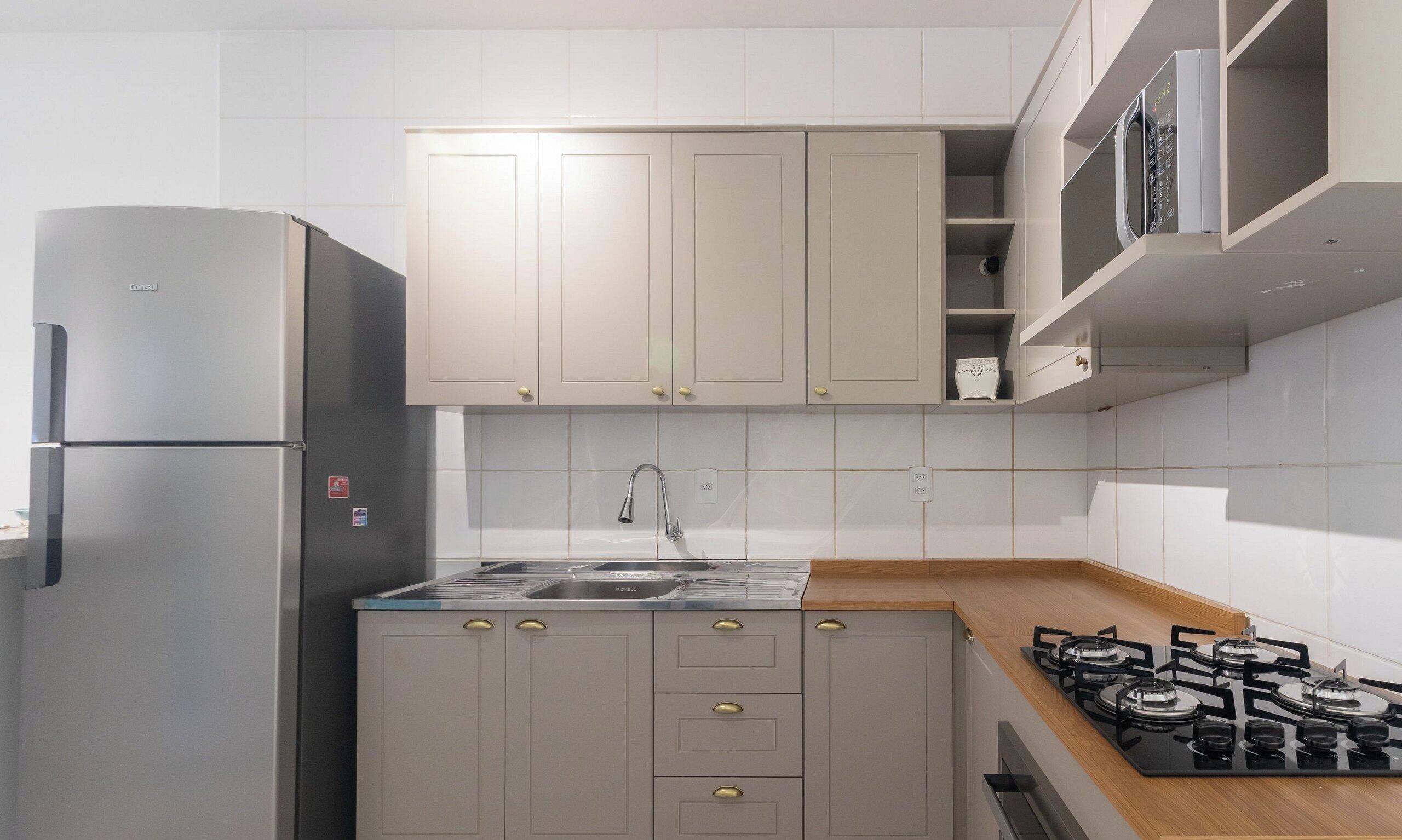 Una cocina moderna con refrigerador de acero inoxidable, estufa a gas y horno integrado.