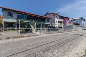 Una strada residenziale con case, un cancello e una strada asfaltata.