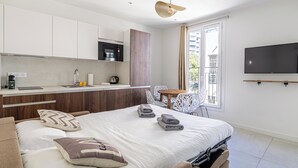 A modern bedroom with a bed, bedside tables, and a TV mounted on the wall. - Luxurious 2-bedroom with terrace 200m from Palais (Cannes)