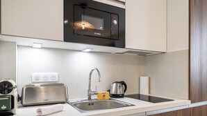 A modern kitchen with a Bosch microwave, a kettle, a toaster, and a sink. - Stunning studio for 2 people 200m from Croisette (Cannes)