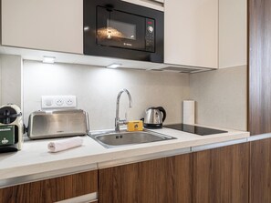 A modern kitchen with a Bosch microwave, a kettle, a toaster, and a sink. - Stunning studio for 2 people 200m from Croisette (Cannes)
