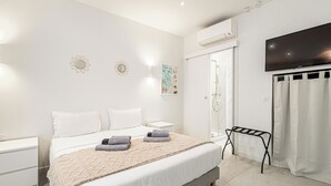 A modern bedroom with a bed, bedside tables, a shower, and a TV. - Stunning studio for 2 people 200m from Croisette (Cannes)
