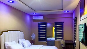 Una camera da letto moderna con un letto grande, una scrivania e una televisione.