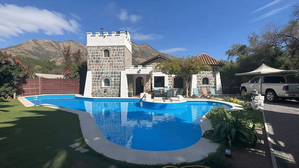 A pool with a stone building, a truck, and mountains in the background. - Oceana Suites San Jose de Maipo (San Jose de Maipo)