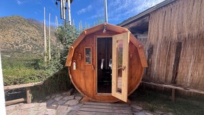 A wooden cabin with a door open, a chimney, and a view of a mountainous landscape. - Oceana Suites San Jose de Maipo (San Jose de Maipo)