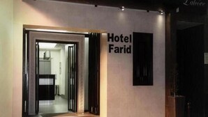 A hotel entrance with a sign reading "Hotel Farid." - Hotel Farid (Dakar)
