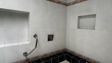 Un baño con bañera, ducha y barra de apoyo.
