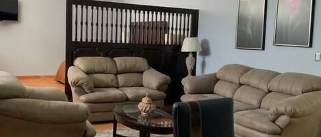 A living room with a sectional sofa, a coffee table, and a TV.
