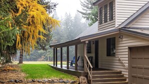 A two-story house with a covered porch, a garage, and a stone marker with the number 240. - Luxury Golf Course Retreat – Sun Country, Cle Elum – Sleeps 8 (Cle Elum)